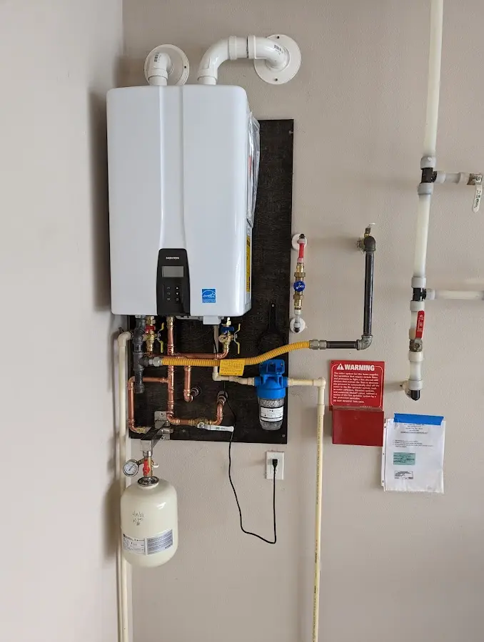 Professional plumber installing copper piping in a Minot home